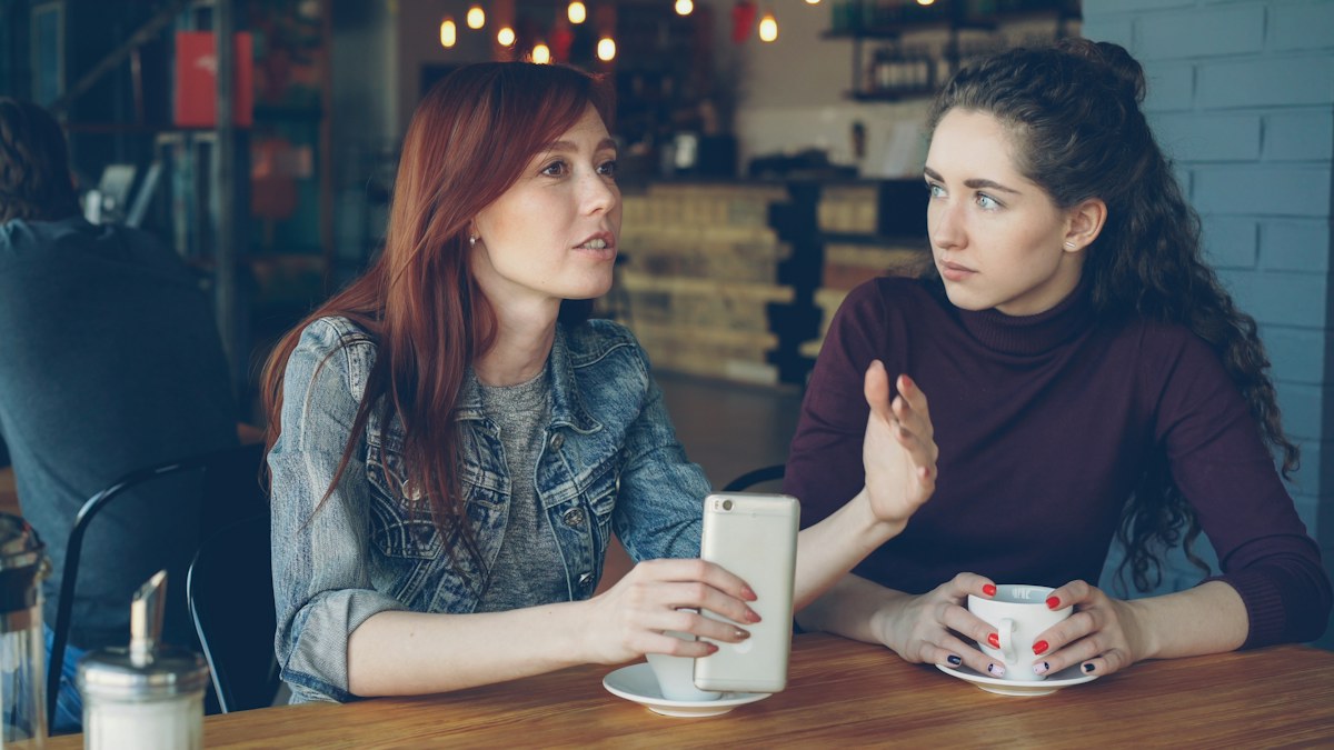 Duas mulheres conversando à mesa — fotografia ilustrativa